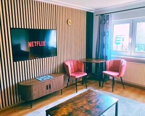a living room with a table and two pink chairs at Willa przy Krupówkach in Zakopane