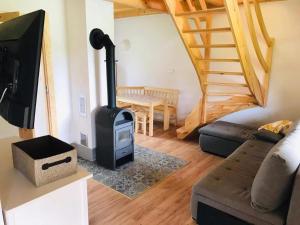 a living room with a wood stove and a couch at Dom nad Wodą in Krąg