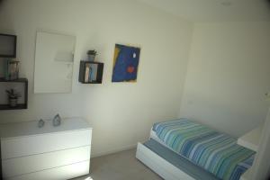 a white bedroom with a bed and a dresser at Mirasole Holiday House in Leggiuno +24 photos