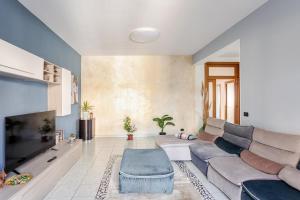 a living room with a couch and a tv at I Due Gelsi Appartamento Blu Cobalto in Monte San Giusto