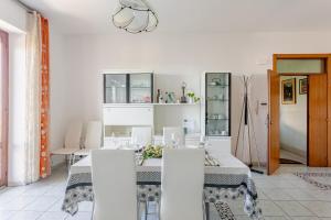 a white dining room with a table and chairs at I Due Gelsi Appartamento Blu Cobalto in Monte San Giusto