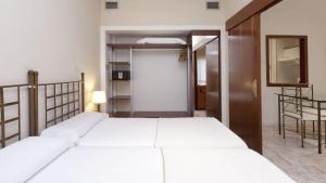 A bed or beds in a room at Apartamentos Vértice Bib Rambla