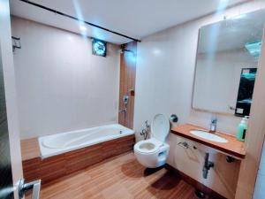 a bathroom with a tub and a toilet and a sink at Hotel Apex Intercontinental in Jaipur