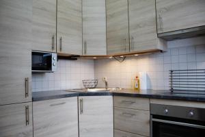 a kitchen with wooden cabinets and a sink and a microwave at Apartment City in Engen