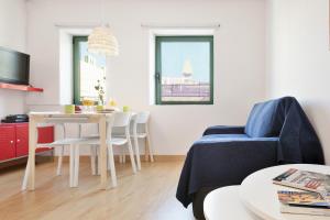 ein Wohnzimmer mit einem Tisch und einem blauen Stuhl in der Unterkunft Ola Living Vidreria in Barcelona + 22 Fotos