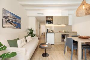 ein Wohnzimmer und eine Küche mit einer Couch und einem Tisch in der Unterkunft Ola Living Vidreria in Barcelona