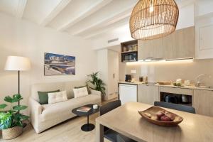 eine Küche und ein Wohnzimmer mit einer Couch und einem Tisch in der Unterkunft Ola Living Vidreria in Barcelona