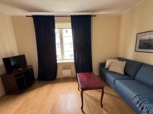 a living room with a blue couch and a tv at Inge Villa Apartment Hotel in Pärnu +32 photos
