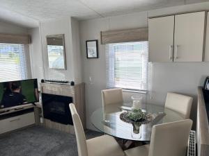 a dining room with a glass table and a television at C&A Retreats in Gisburn