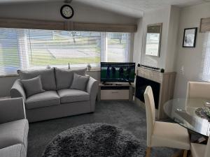 a living room with a couch and a television at C&A Retreats in Gisburn