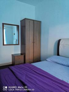 a bedroom with a bed and a dresser and a mirror at PD WORLD MARINa in Port Dickson