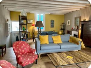 - un salon avec un canapé bleu et un fauteuil rouge dans l'établissement Maison spacieuse hyper centre - 5à7p - Terrasse privée, à Les Sables-dʼOlonne