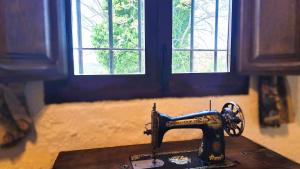 a sewing machine sitting on a table in front of two windows at Suitur Cortijo de Don Lolo in La Carrera de la Viña