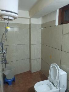 a bathroom with a toilet with the seat up at Hotel Cafeteria Roof in Kalpa