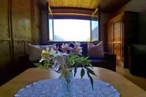 a vase of flowers on a table in a room at Landhaus Rasser in Rauris