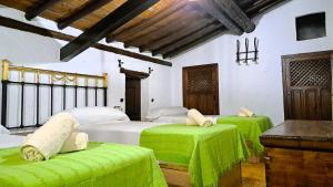 a bedroom with two beds with green sheets at Suitur Cortijo de Don Lolo in La Carrera de la Viña +39 photos