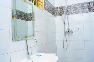 a bathroom with a shower with a sink and a mirror at Kanye Bridge Hotel Jinja in Jinja +63 photos