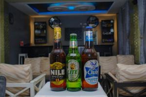 three bottles of beer sitting on top of a table at Kanye Bridge Hotel Jinja in Jinja