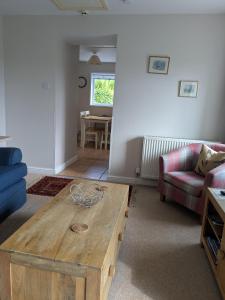 a living room with a wooden coffee table and a couch at Boreland Farm in Dunscore +15 photos
