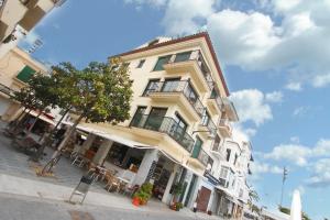 un edificio alto amarillo con un árbol delante de él en ACP Cambrils Puerto Apartamentos, en Cambrils