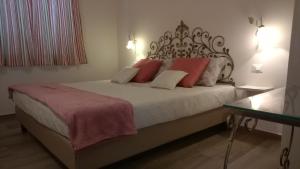 ラ・スペツィアにあるIl Porto dei Sognatoriのベッドルーム1室(大型ベッド1台、赤と白の枕付)