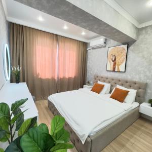 a bedroom with two beds and a couch at Great Cozy Apt in the heart of the city TU116 in Almaty