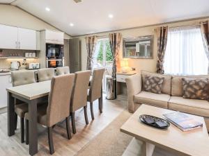 a living room with a couch and a table and chairs at Glenridding Lodge in Windermere +17 photos