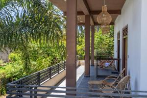 a person sitting on the porch of a house at Ethera Arugam bay in Arugam Bay
