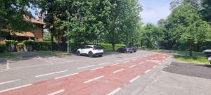 a white car is parked in a parking lot at Villa I Cigni Holidays Home in Arona