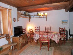 a dining room with a table and chairs and a television at Ancient Engadine Mill in Scuol