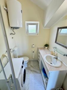 a bathroom with a sink and a toilet and a mirror at Boka Bay Apartments in Herceg-Novi +54 photos