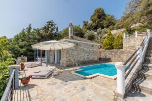 an external view of a villa with a swimming pool at Villa Galazopetra in Skopelos Town