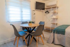 a room with a table and chairs and a bed at Estudio Nivalis El Rio in Monachil +12 photos