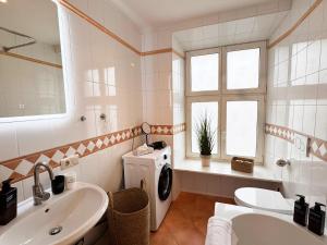 a bathroom with a sink and a washing machine at ma suite - city sol apartment - centrum - private parking in Augsburg +10 photos
