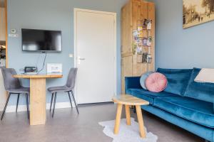 a living room with a blue couch and a table at Bed & Breakfast de Lindevallei in Oldeberkoop