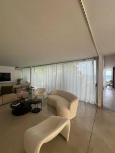 a living room with white furniture and a large window at Villa Marta in Alicante