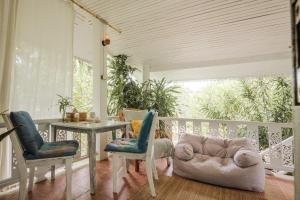 una veranda con un divano, un tavolo e delle sedie di Sunset beach villa 3 O3 villas a Ko Phangan