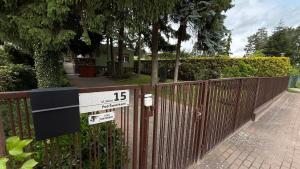 a fence with a sign on it next to a house at Pod Świerkami in Boszkowo