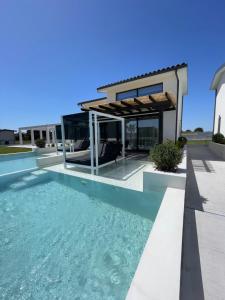 a swimming pool in front of a house at Villa Palma in in Kallithea Halkidikis