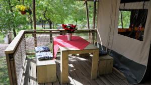 a table with a vase of flowers on a deck at Lodge Holidays - Casa Tartufo in Radicosa +24 photos