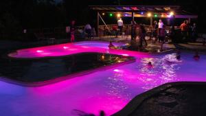a pool with pink lights in the water at night at Lodge Holidays - Casa Tartufo in Radicosa