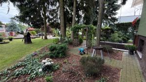 a garden with a statue of a woman holding an umbrella at Pod Świerkami in Boszkowo