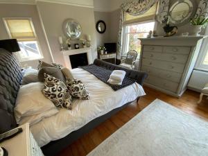 a bedroom with a bed with pillows and a fireplace at Victorian Retreat - A Serene Sanctuary in Broadstairs