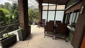a patio with a table and chairs on a balcony at Pod Świerkami in Boszkowo