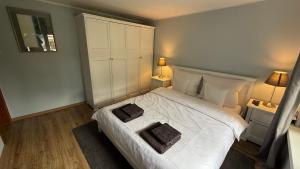 a bedroom with a white bed with two pillows on it at Pod Świerkami in Boszkowo