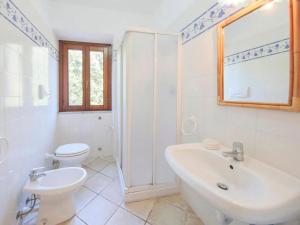 une salle de bain blanche avec un lavabo et des toilettes dans l'établissement Casa Novella - Argonauti Vacanze, à Procchio
