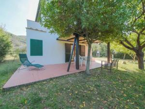 a house with a chair next to a tree at Casa Novella - Argonauti Vacanze in Procchio