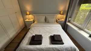 a bedroom with a white bed with two towels on it at Pod Świerkami in Boszkowo