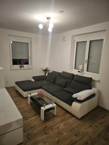 a living room with a large couch and two windows at Ferienwohnung Christian in Stinatz