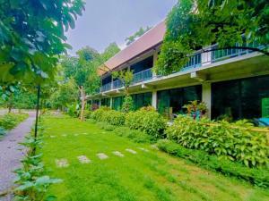 ein Gebäude mit einem Rasen davor in der Unterkunft คีรีเขาสกริเวอร์ in Khao Sok